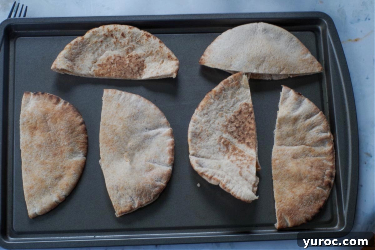 Wholesome Pita Pizza Pouches 8 Pita halves neatly arranged on a baking sheet, ready for filling.
