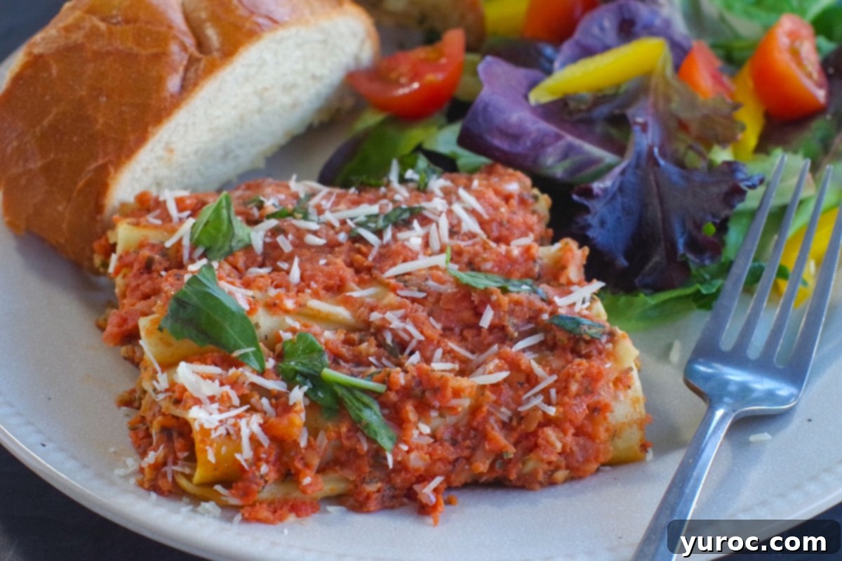 baked beef cannelloni on plate with garlic toast and garden salad, a perfect Italian dinner