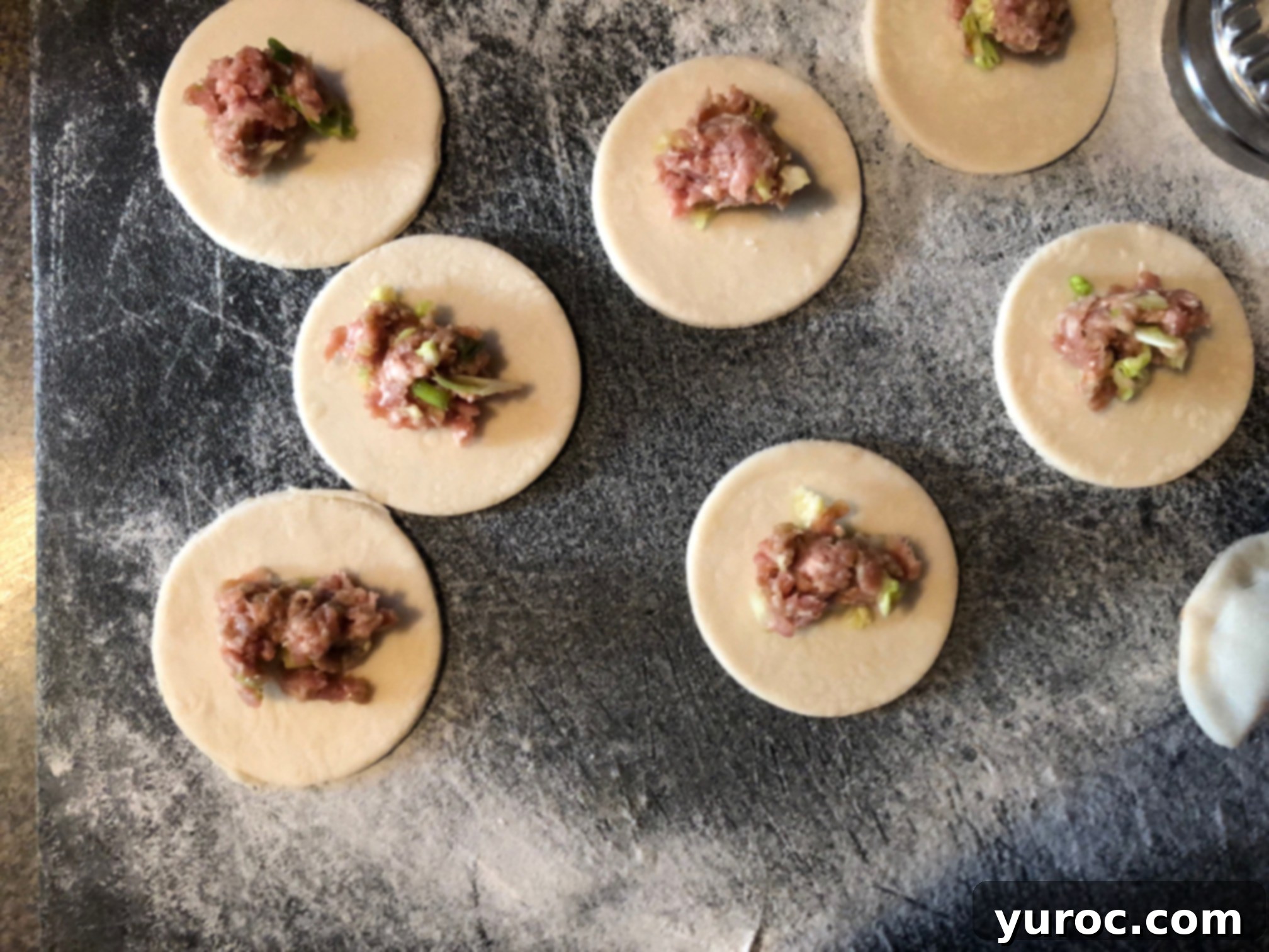 Adding 1 teaspoon of savory filling to each Chinese potsticker wrapper