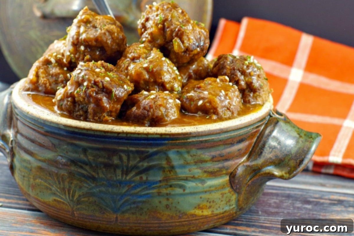 Sticky Sweet and Sour Slow Cooker Meatballs 2 Sweet & Sour Slow Cooker Meatballs piled high in a blue grey ceramic dish with an orange and white checked tea towel in the background.