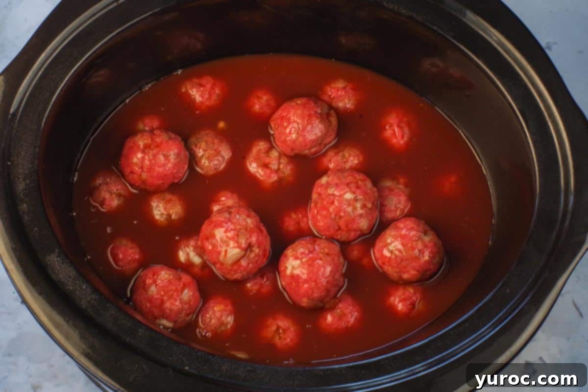 Sticky Sweet and Sour Slow Cooker Meatballs 11 Sauce poured over meatballs in slow cooker.
