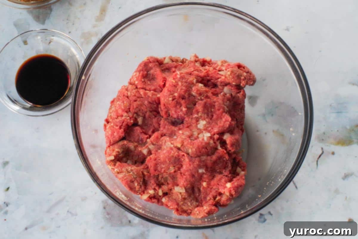 Sticky Sweet and Sour Slow Cooker Meatballs 5 Meatball ingredients mixed together in a large glass bowl.