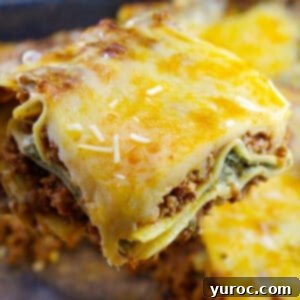 Prep-Ahead No-Boil Lasagna 18 piece of lasagna being held up over container of lasagna