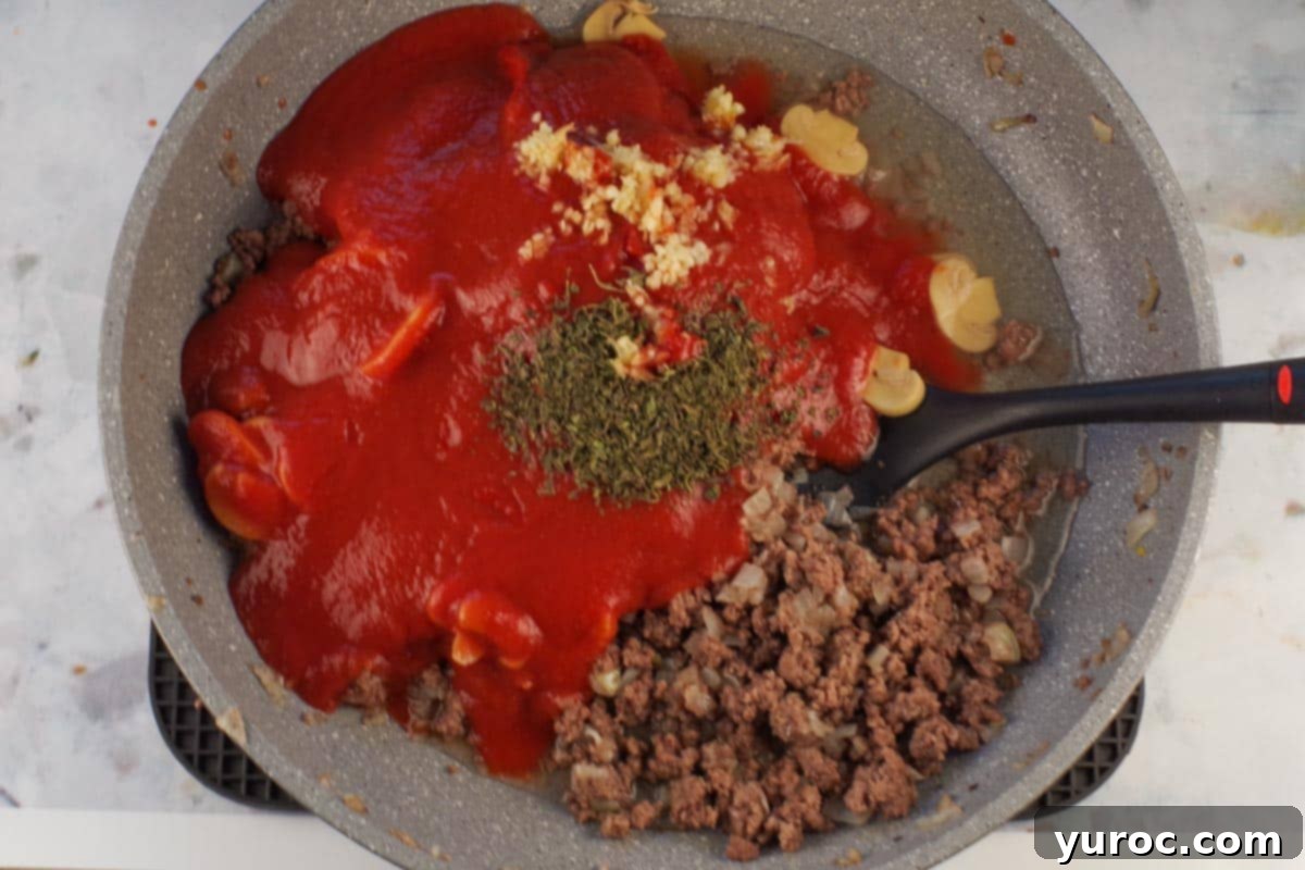 Prep-Ahead No-Boil Lasagna 4 Ground beef with sauce ingredients including oregano, mushrooms, tomato sauce, and garlic added to skillet