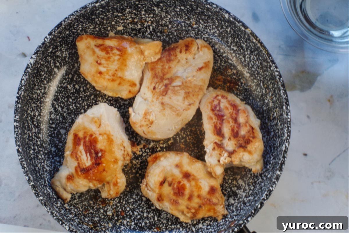 5 cooked chicken breasts in a frying pan