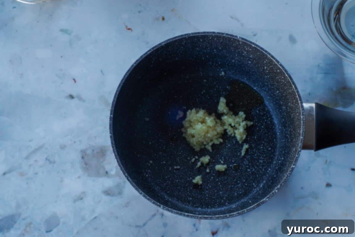 garlic and oil sauteing in a small dark pot