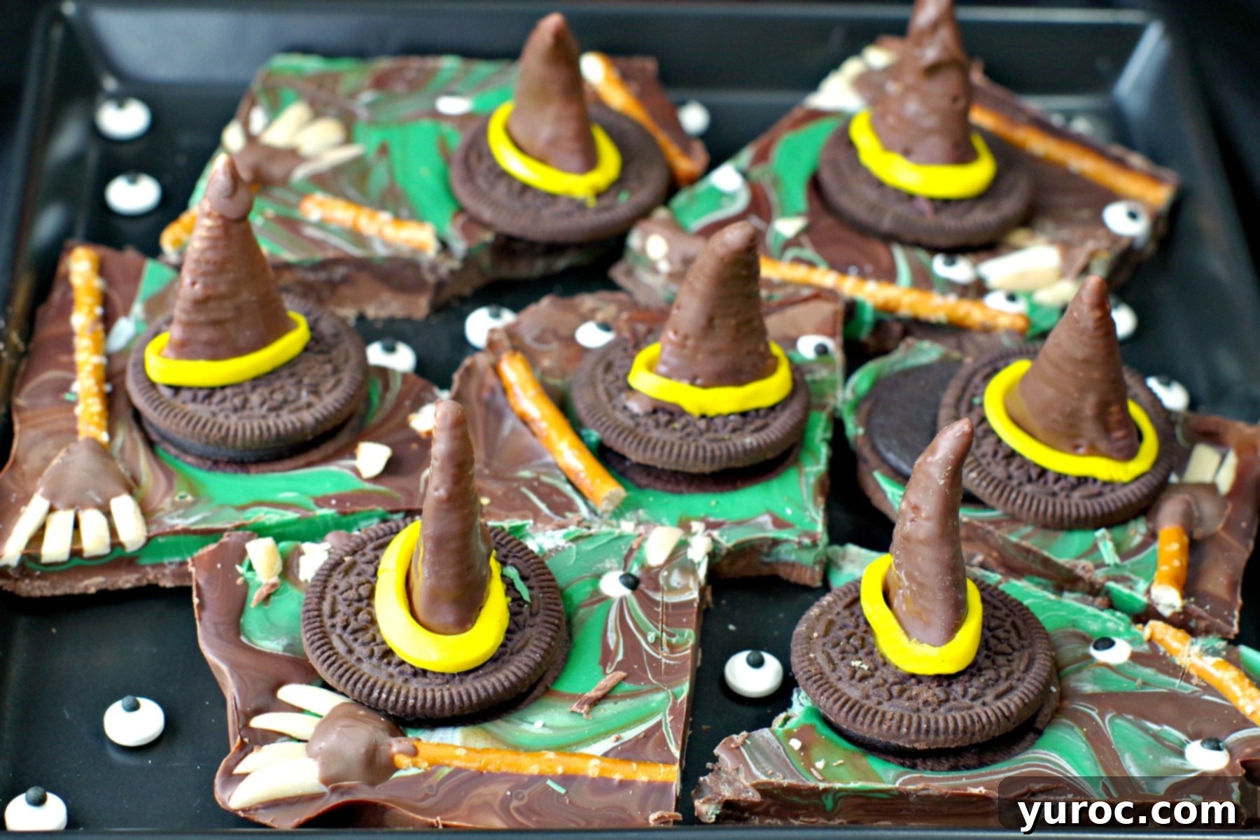 Witch's Meltdown Halloween Punch 4 Melting Witch Halloween Chocolate Bark broken into pieces on black platter with extra candy eyes scattered on plate