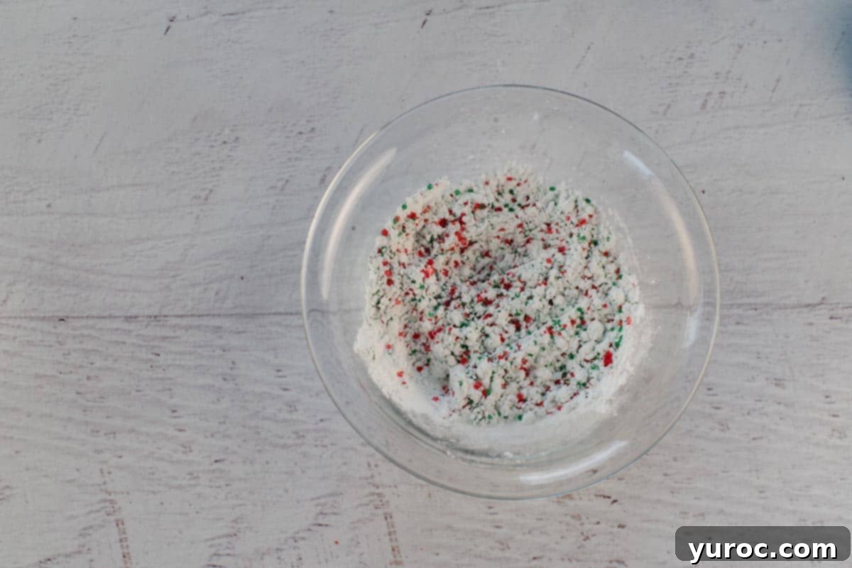 Winter Spice Almond Snow Puffs 12 Powdered sugar mixed with red and green sparkling sugar, ready for coating.