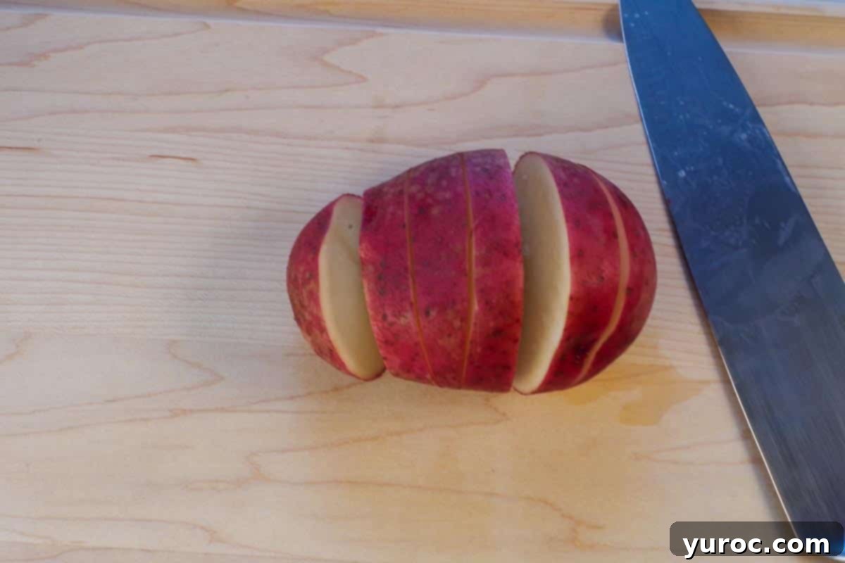 French Onion Baked Potatoes 5 potato with 5 cuts in it on cutting board
