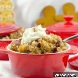 Cranberry gingerbread rice pudding in a red bowl with gingerbread men and more red bowls in background.