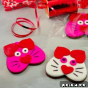 Purr-fect Heart-Shaped Cat Treats 11 pink and white cat cookies on grey surface