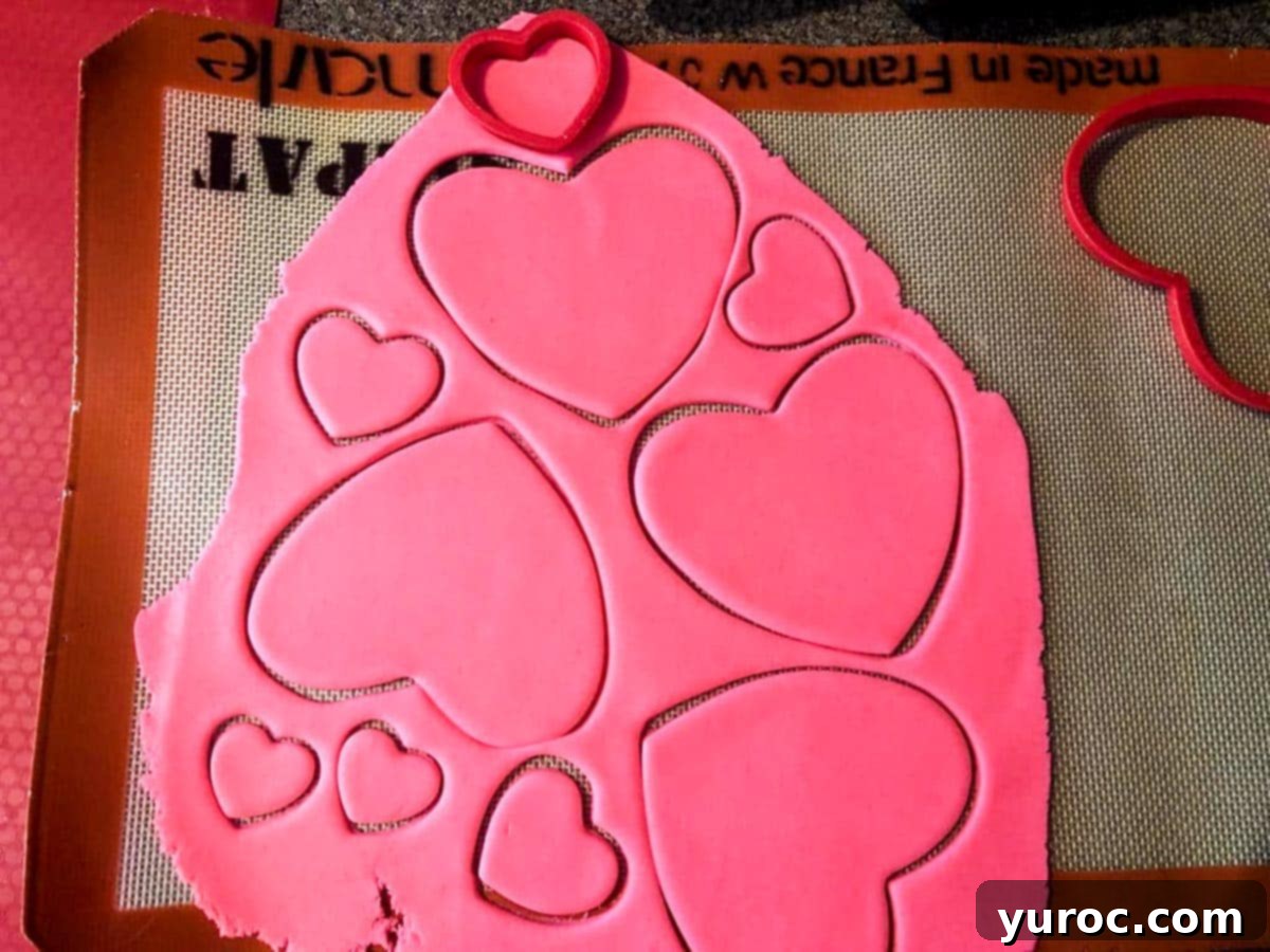 Purr-fect Heart-Shaped Cat Treats 3 pink fondant rolled out with heart shapes cut into it