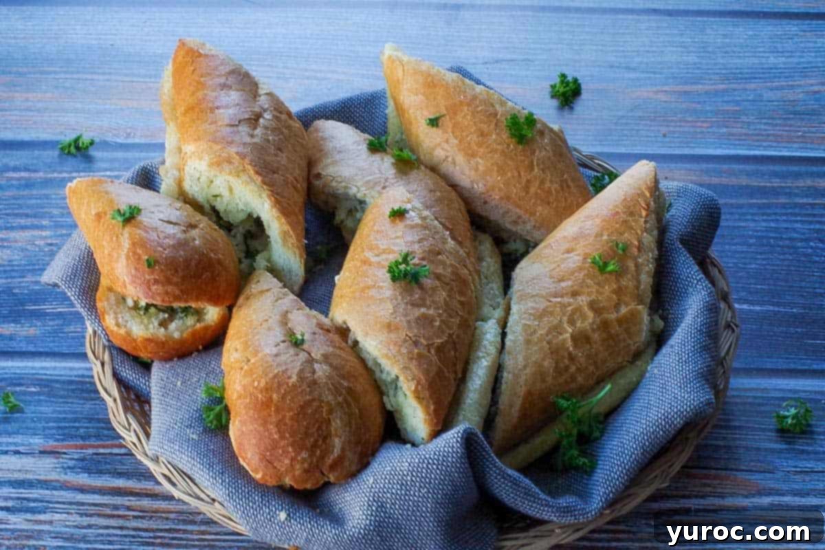 Sliced baguette garlic bread arranged in a small basket with a grey fabric liner