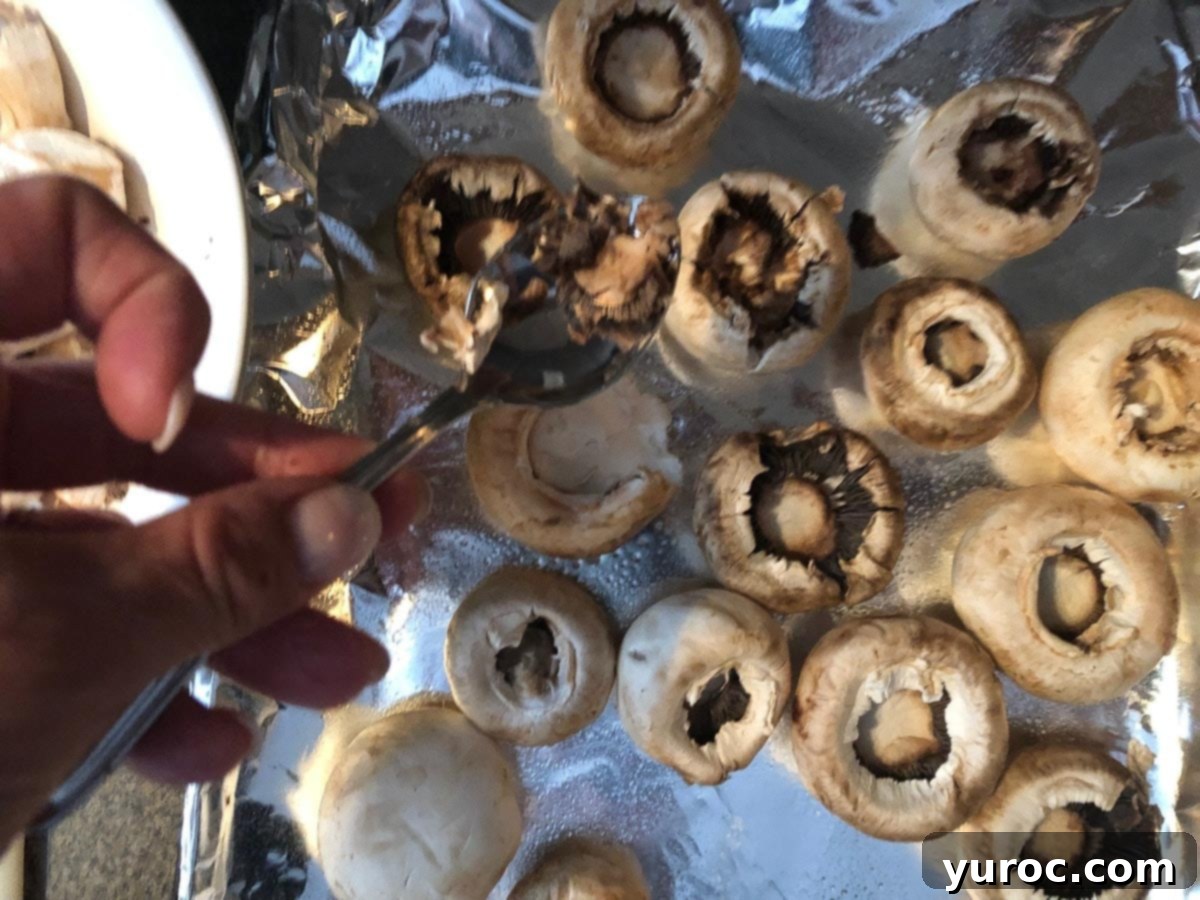 Pierogi Mushroom Bites 4 Mushroom caps being gently scooped out to make room for stuffing