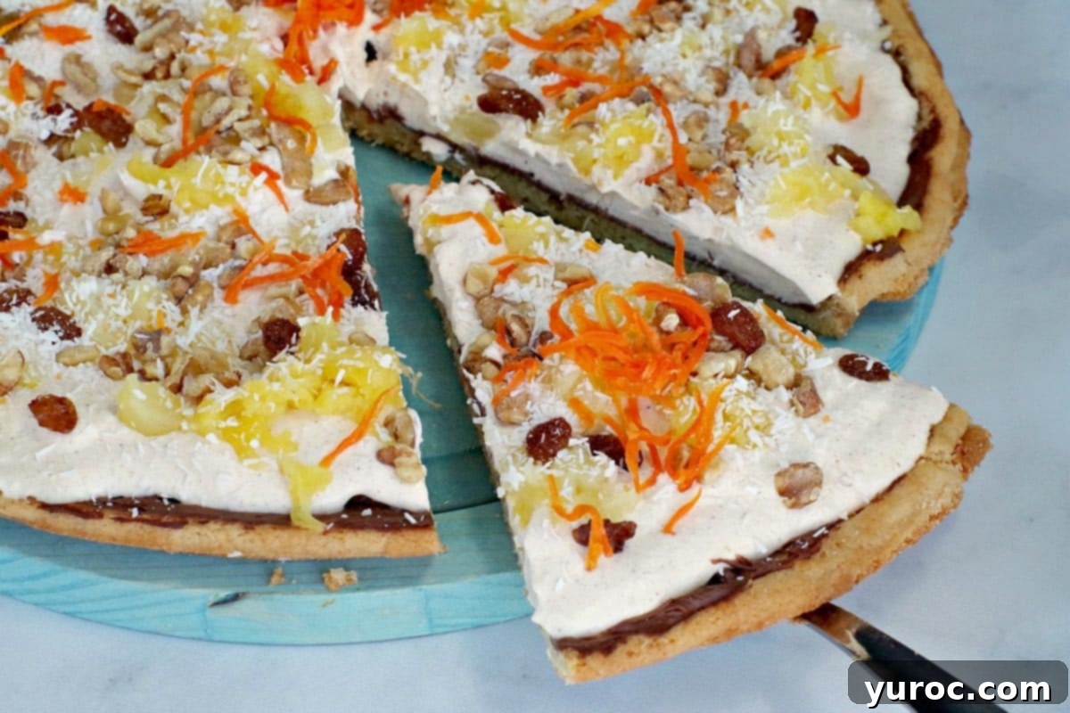 A slice of carrot cake dessert pizza being removed from a platter.