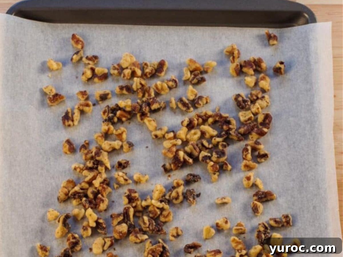 Toasted walnuts on parchment covered baking sheet.