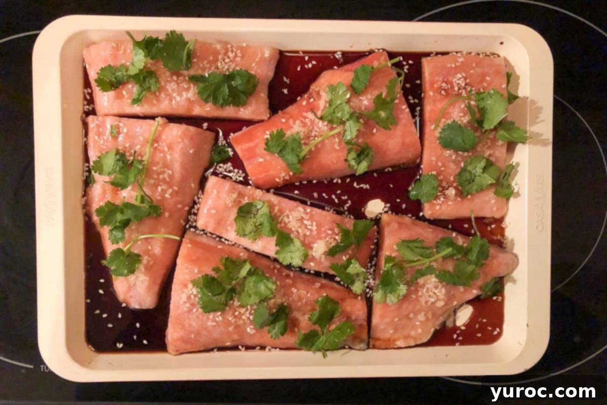 Frozen Weight Watchers salmon fillets on a sheet pan, seasoned and ready for the oven.