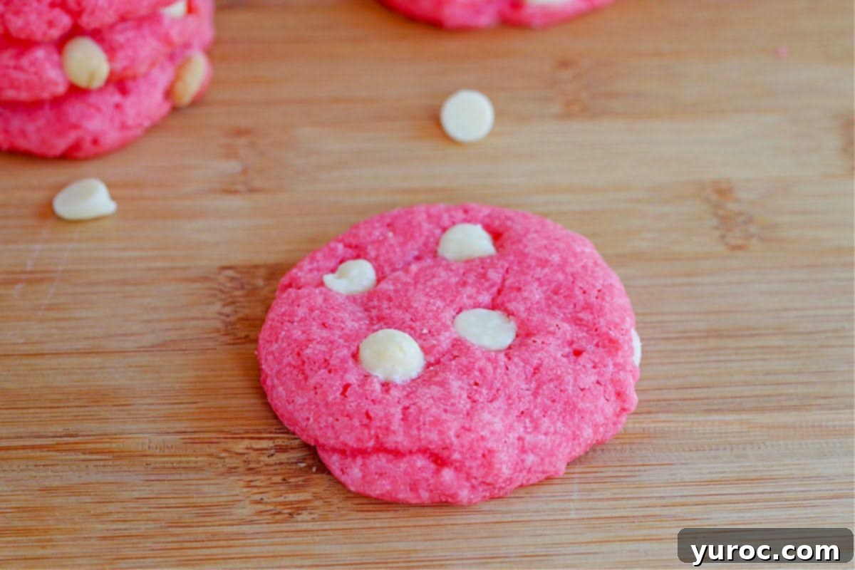 Dreamy Strawberry Milkshake Cookies 6 strawberry milkshake cookie on wooden cutting board with a couple of cookies in the background