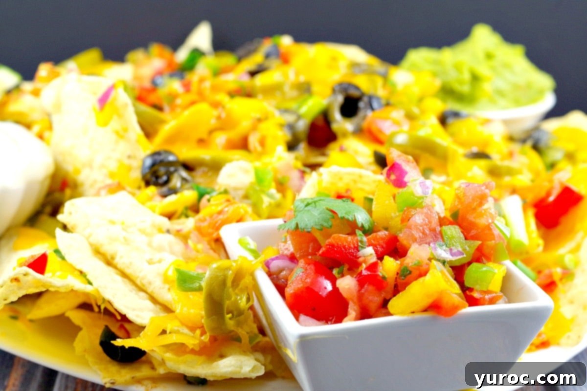 Bright & Zesty Pico de Gallo 3 Pico de Gallo Salsa on plate of nachos (with the works) and a small white dipping bowl of salsa in the foreground