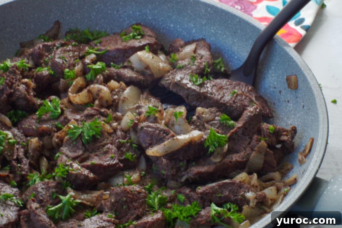 Slow Cooker Smothered Swiss Steak 11 cooked venison steak in a skillet with a spatula turner