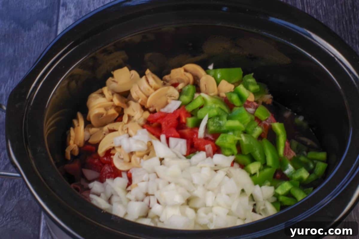 Slow Cooker Smothered Swiss Steak 6 onion, diced tomatoes, green pepper and garlic added over steak in slow cooker