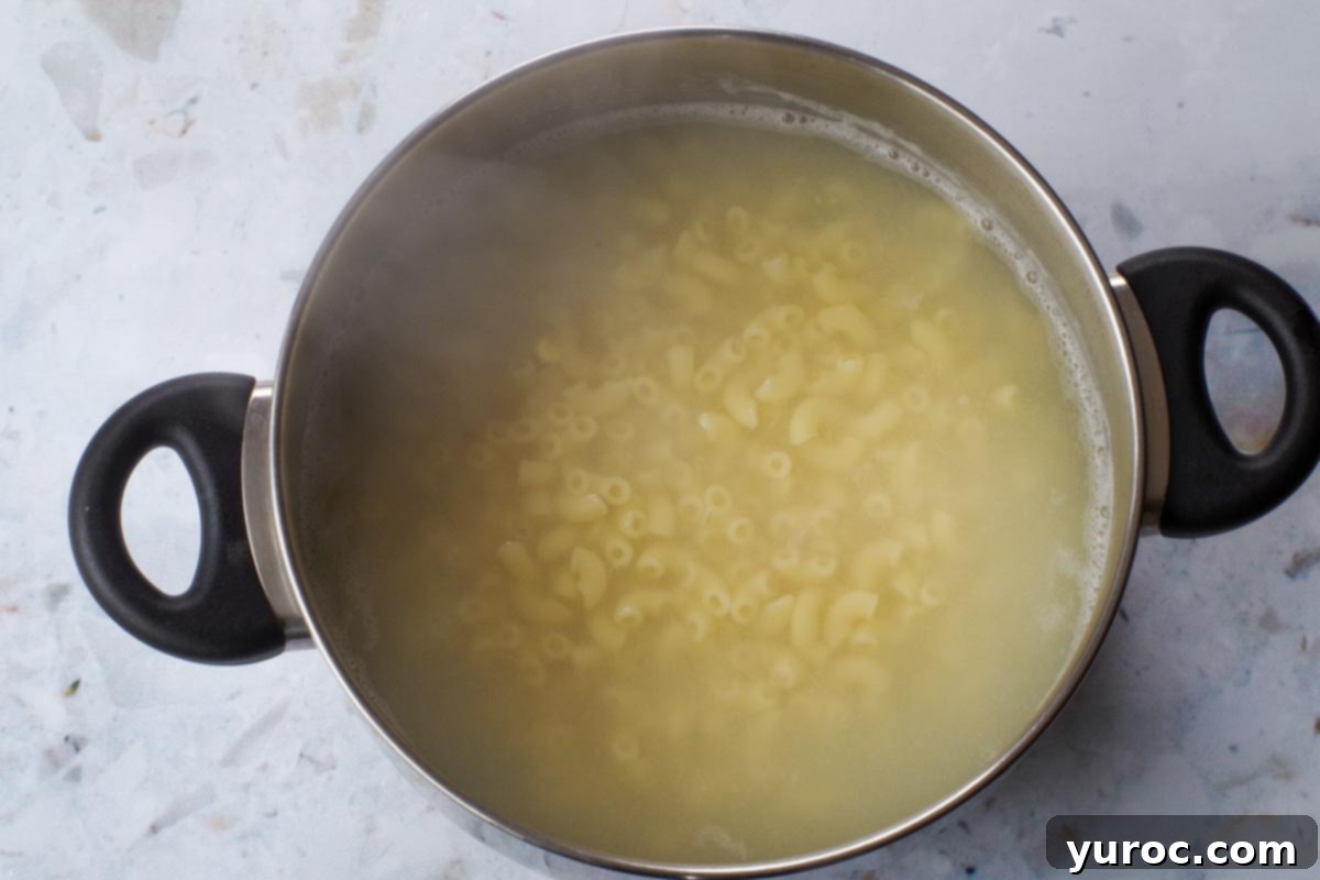 Wholesome Tuna Macaroni Salad 4 Macaroni being cooked in a pot of boiling water.