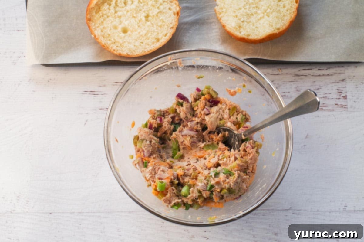 ingredients in tuna melts mixed together in medium glass bowl with a spoon