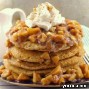 Stacked IHOP copycat harvest grain and nut pancakes with apple topping and whipped cream