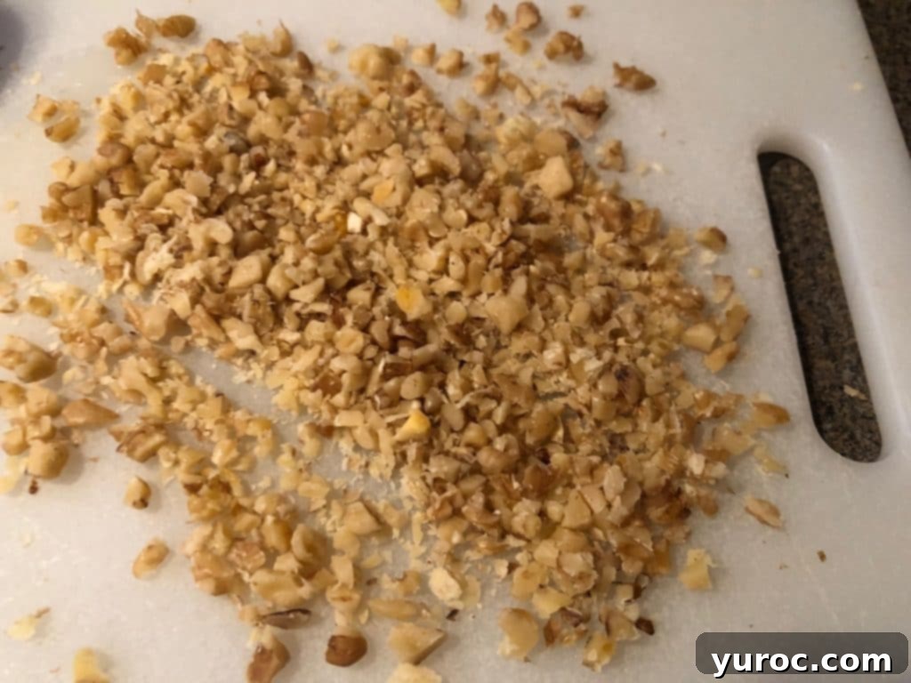 Finely chopped walnuts on a white cutting board