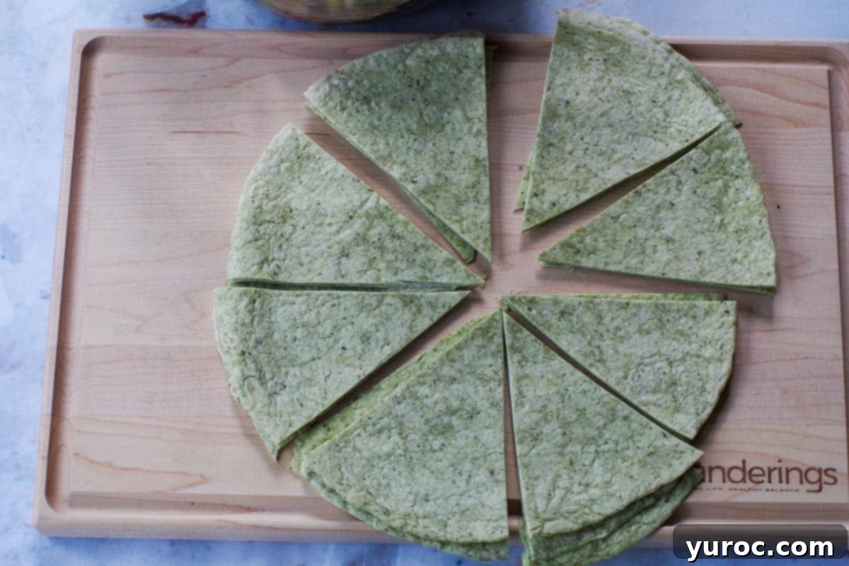 Large tortillas cut into 8 pieces on a wooden cutting board.