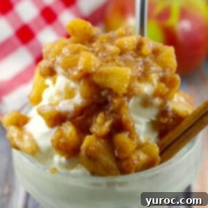 Warm Apple Cinnamon Topping 9 Apple topping on frozen yogurt in glass dessert dish with apple and red and white checkered cloth in background