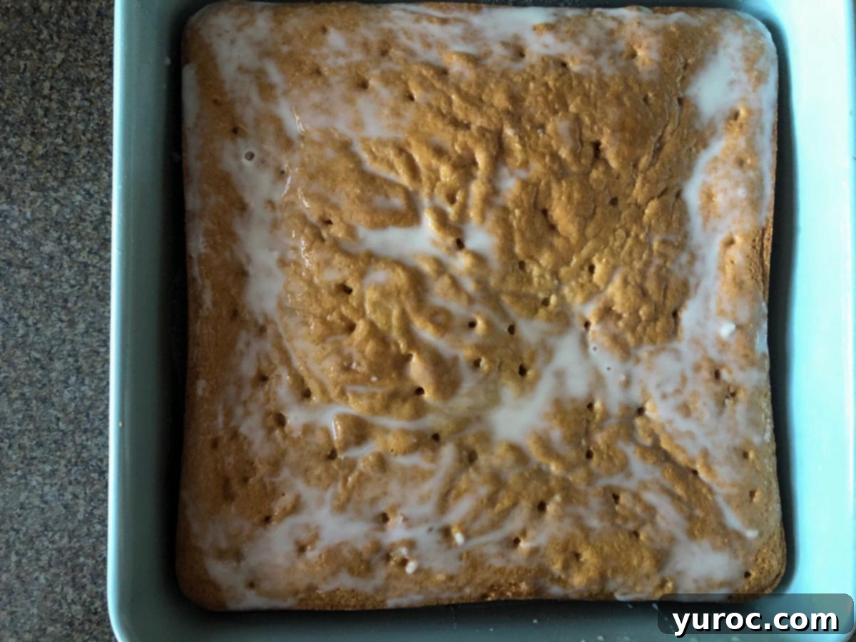 Tropical Lime Coconut Tres Leches 5 Half of the milky coconut syrup is poured slowly over the poked cake, allowing it to begin absorbing the liquid.