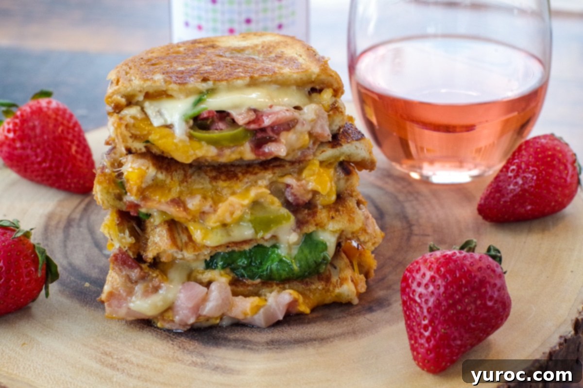 Strawberry Moscato grilled cheese on wooden tree platter with glass of moscato in background and strawberries