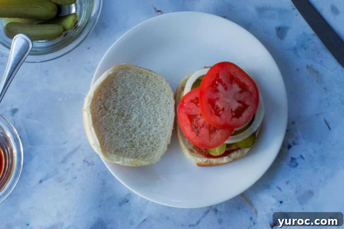 Pickles, onions and tomato added to the top of the burger.