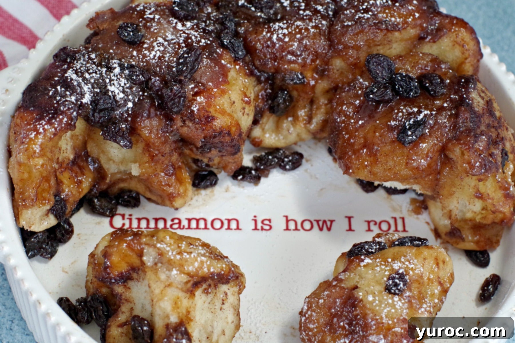 Overnight Caramel Cinnamon Buns 4 Overnight Cinnamon Sticky Buns in white dish with writing "cinnamon is how I roll", showing the soft texture and glazed topping.