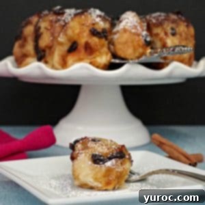 Overnight Caramel Cinnamon Buns 6 cinnamon sticky buns on a white cake stand in background, with a single bun on a white plate in front