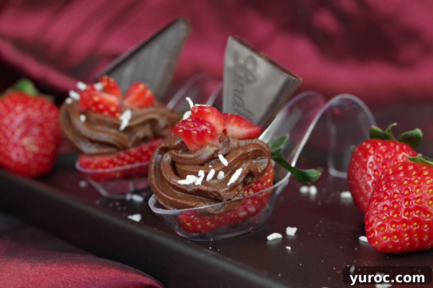 Two beautifully assembled Chocolate Avocado & Strawberry mini desserts on elegant spoons, resting on a black appetizer tray, showcasing the final presentation.