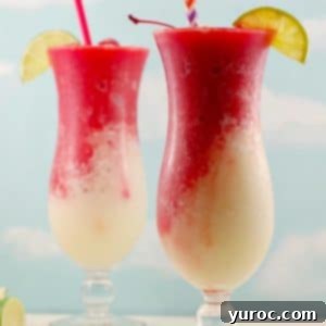 2 Miami Vice drinks on white wooden surface with a blue sky background