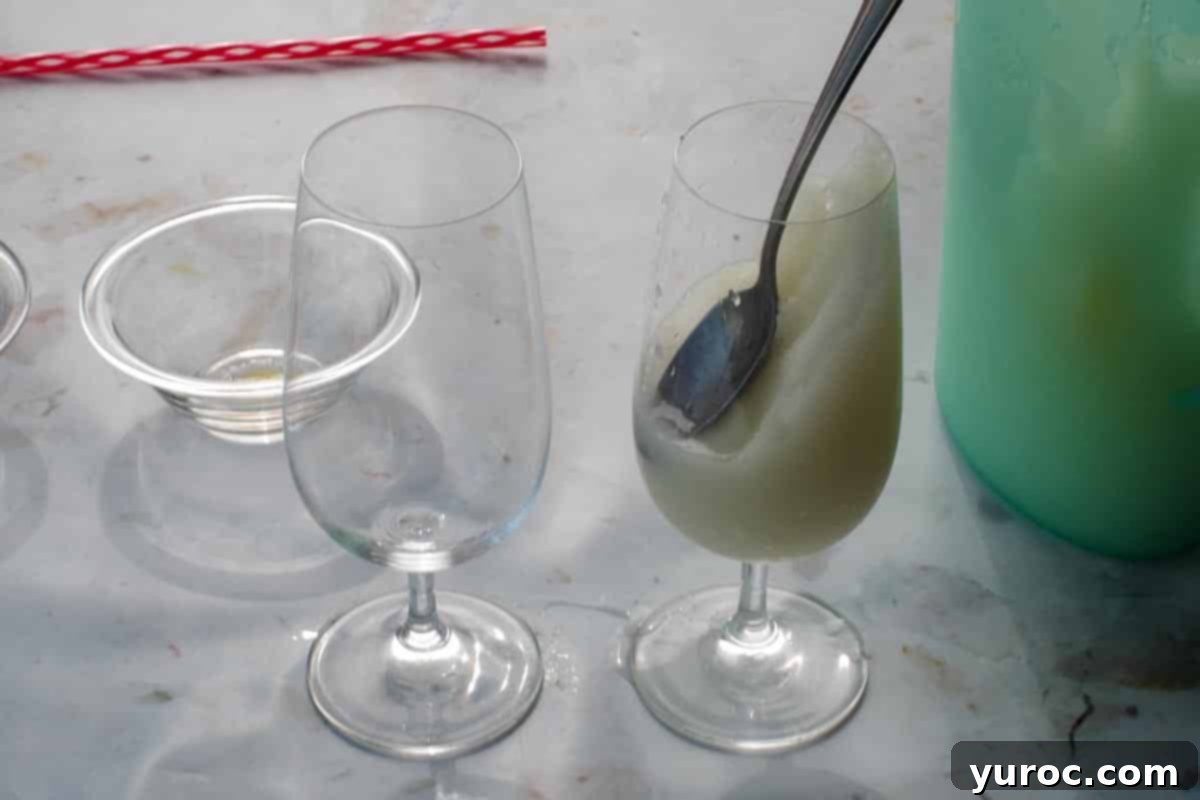 Pina Colada mixture poured into glass and pushed down on an angle with a spoon.