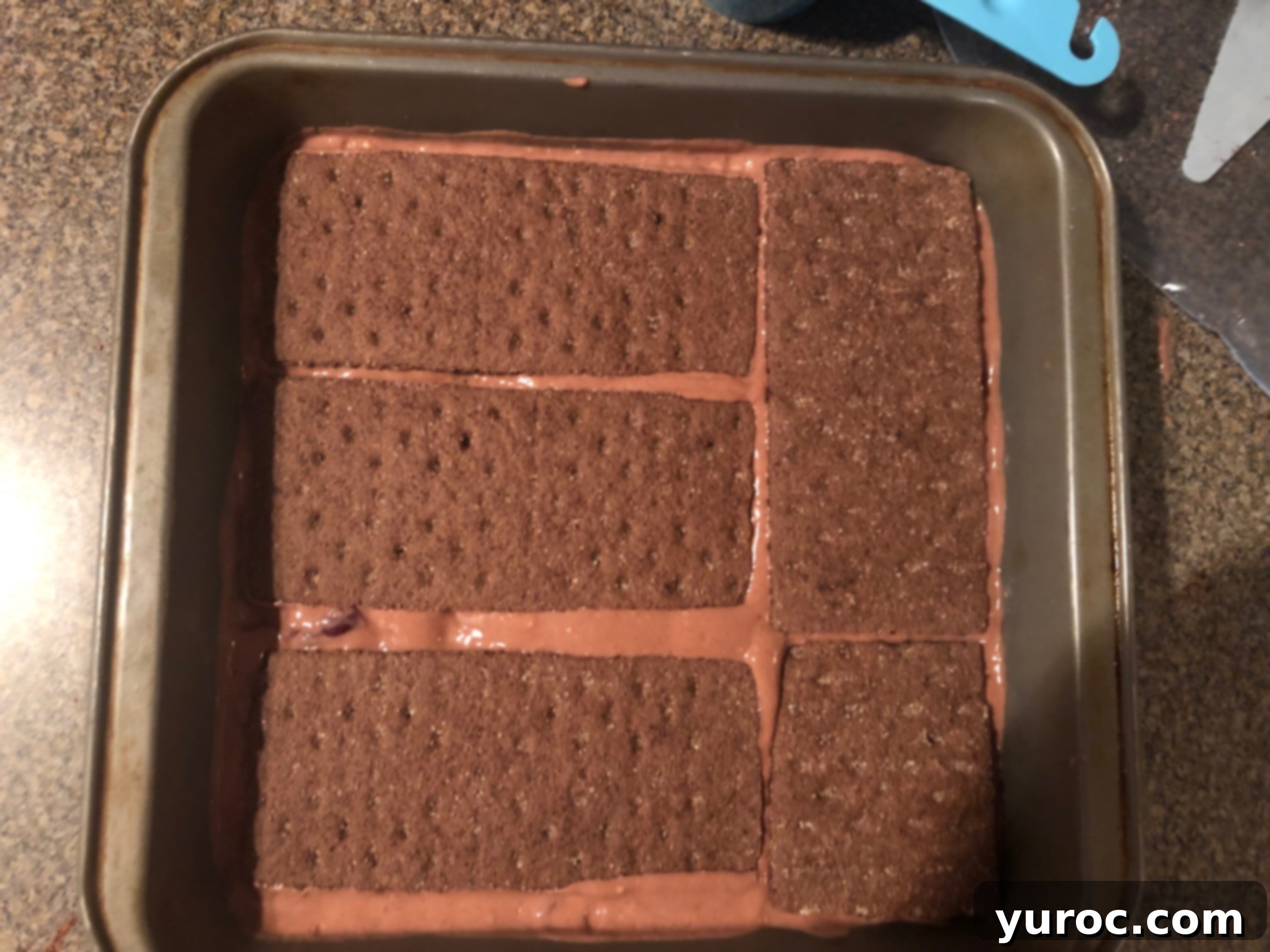 The chocolate yogurt filling topped with a second layer of graham crackers, ready for freezing.