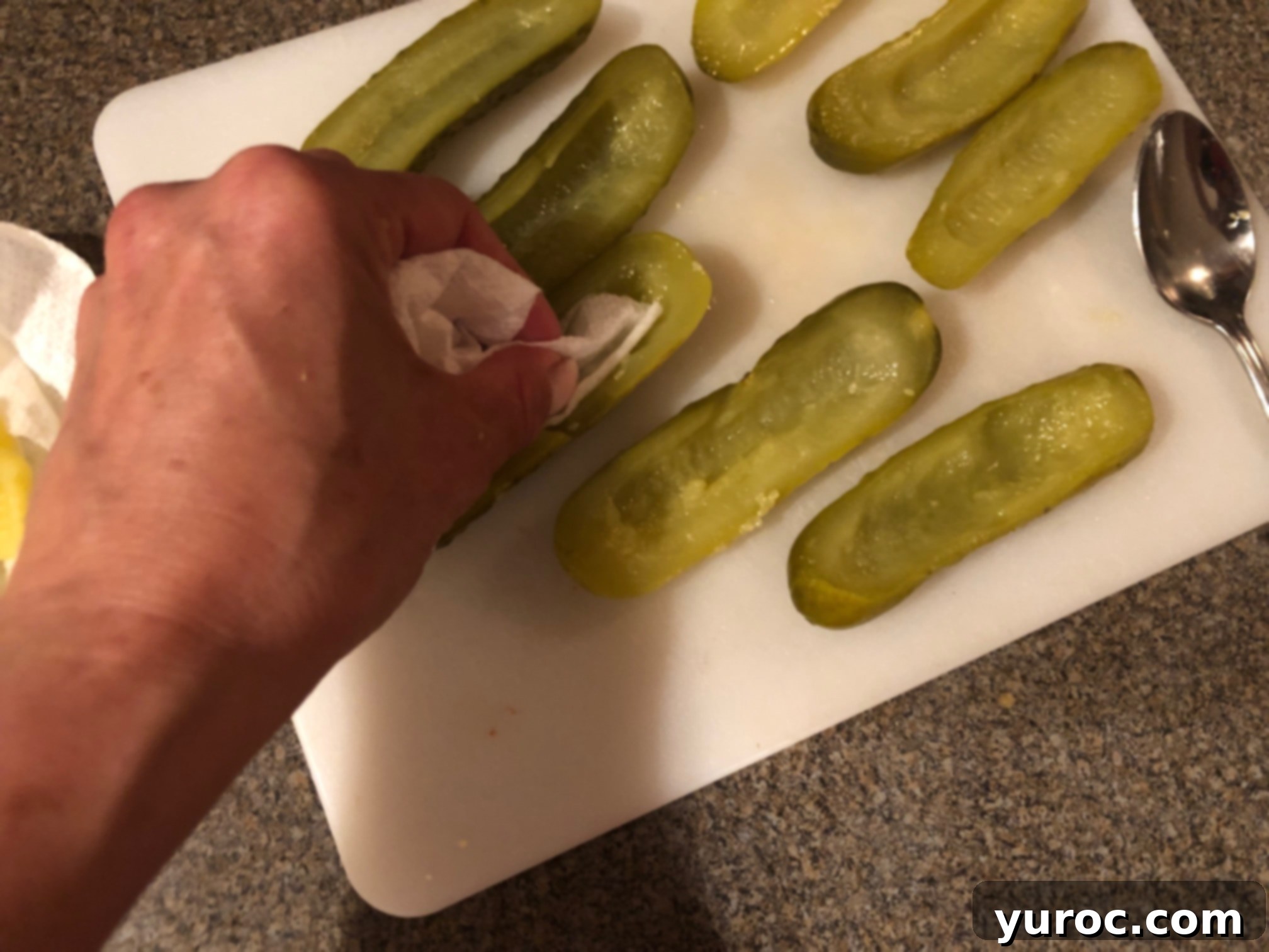 Creamy Boursin Pickle Bites 7 A paper towel gently dabbing and drying the inside of a hollowed pickle half to remove excess moisture