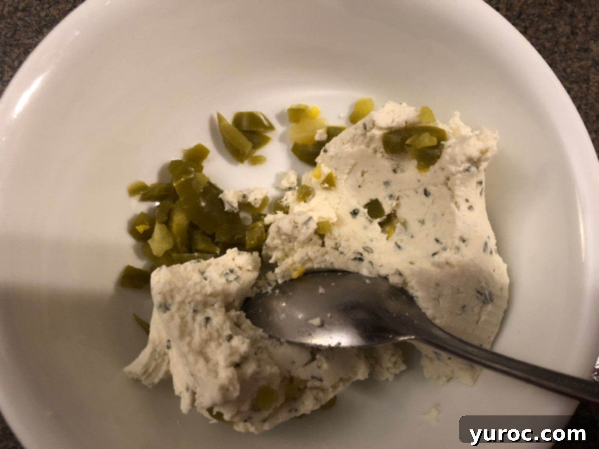 Creamy Boursin Pickle Bites 9 Creamy Boursin cheese being mixed thoroughly with finely chopped jalapeños in a small mixing bowl