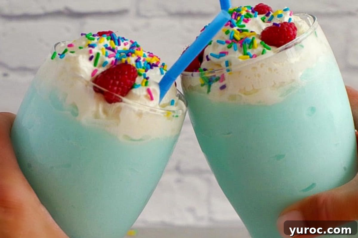 Two non-alcoholic Blue Raspberry Slushie drinks being clinked together in a celebratory toast.