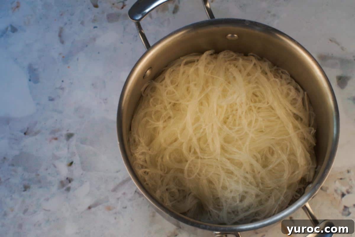Drained vermicelli noodles cooling in a medium-sized pot, ready for the next step in the salad recipe.