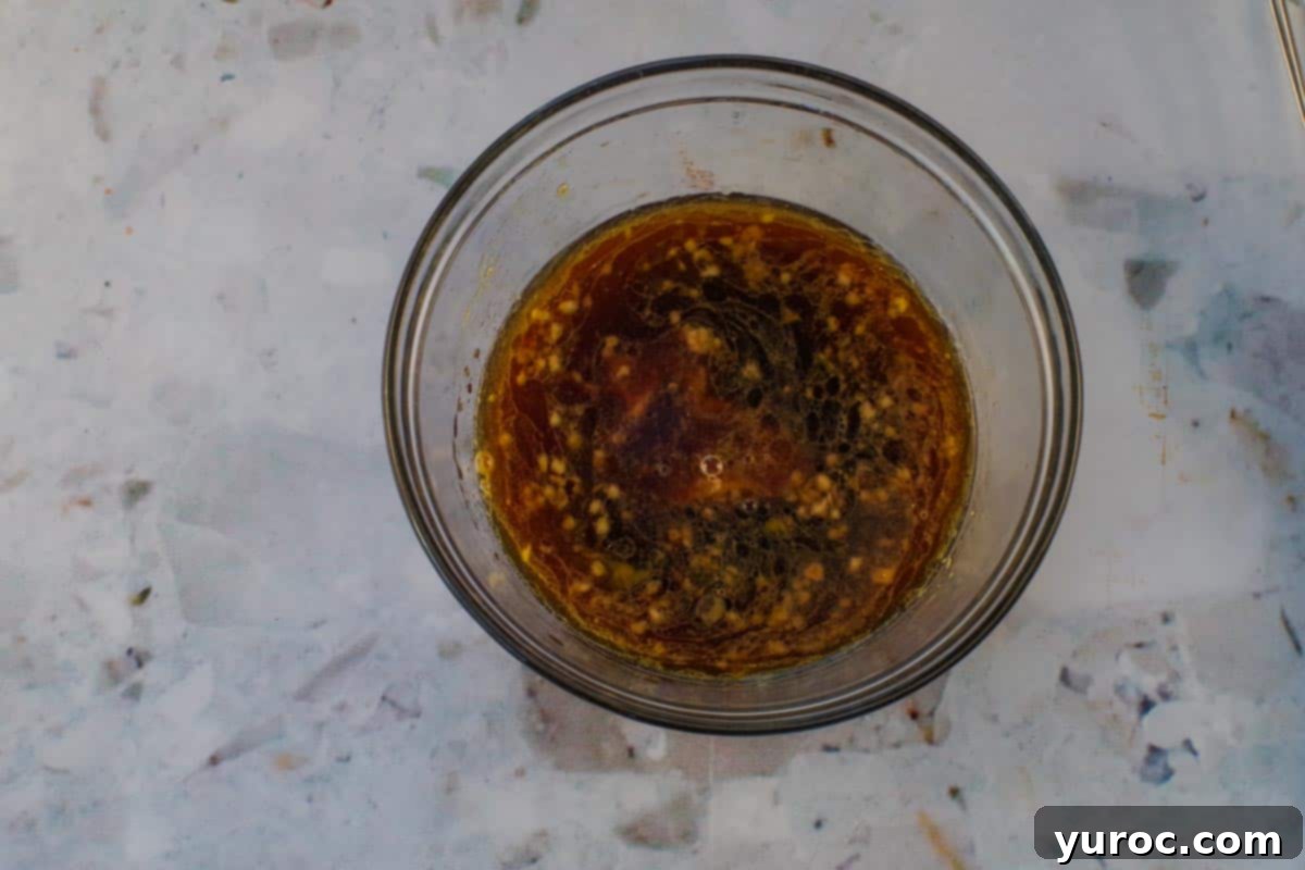 All ingredients for the peanut salad dressing placed in a microwave-safe glass bowl, ready to be heated.