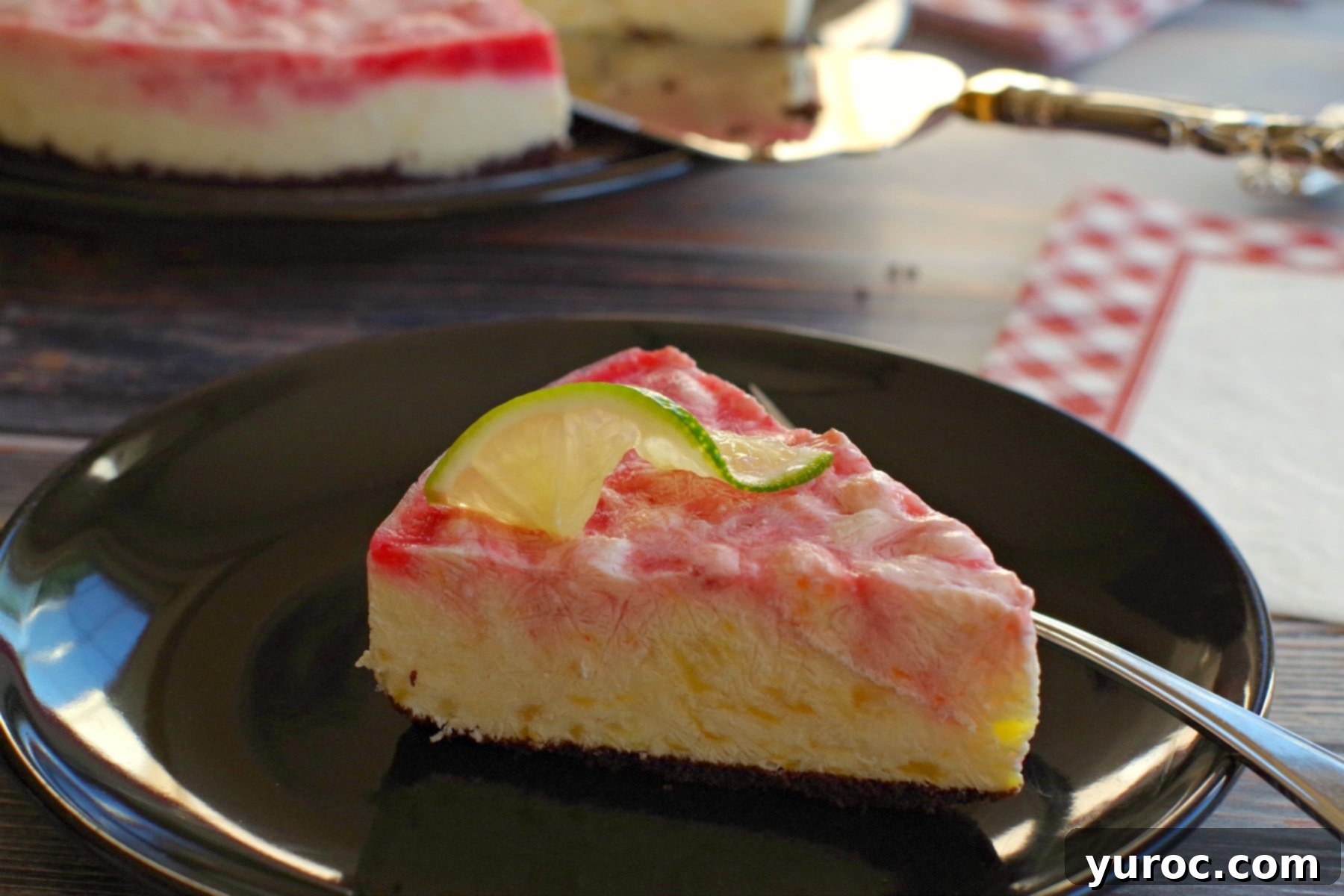 A stunning Miami Vice Frozen Cheesecake, beautifully swirled in red and white, set against a backdrop of fresh limes, embodying a perfect summer celebration dessert.