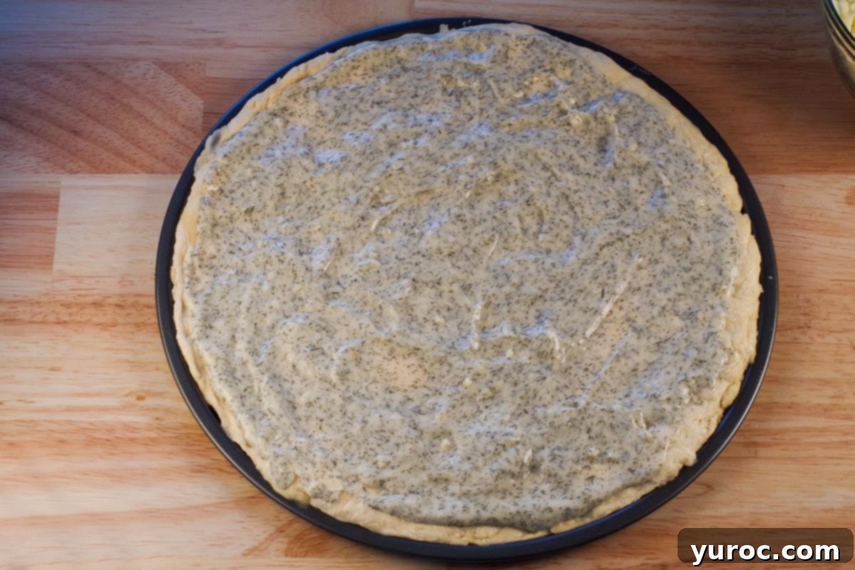 Sauce spread on pizza dough.