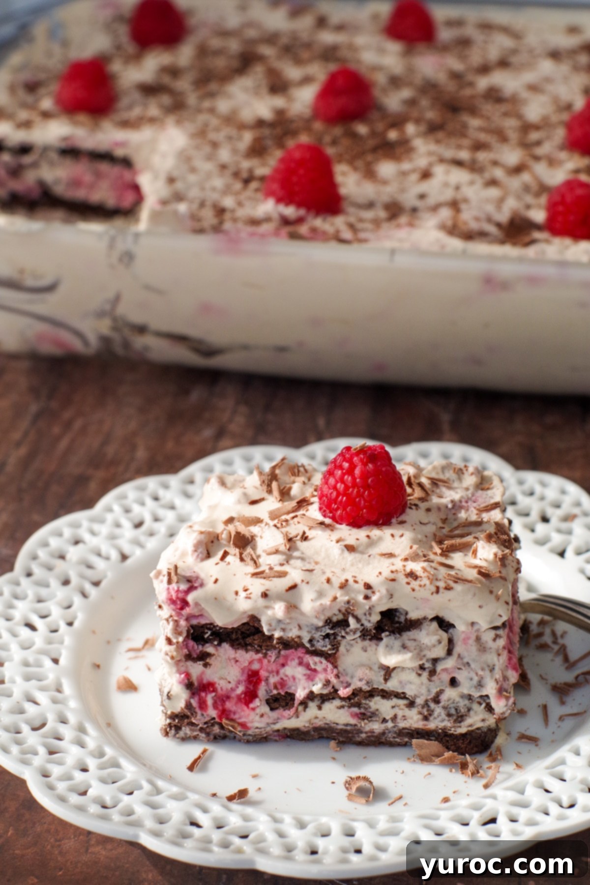 Decadent Dulce De Leche Chocolate Raspberry Icebox Cake 18 raspberry dulce de leche icebox cake on white plate with glass dish of cake in the background