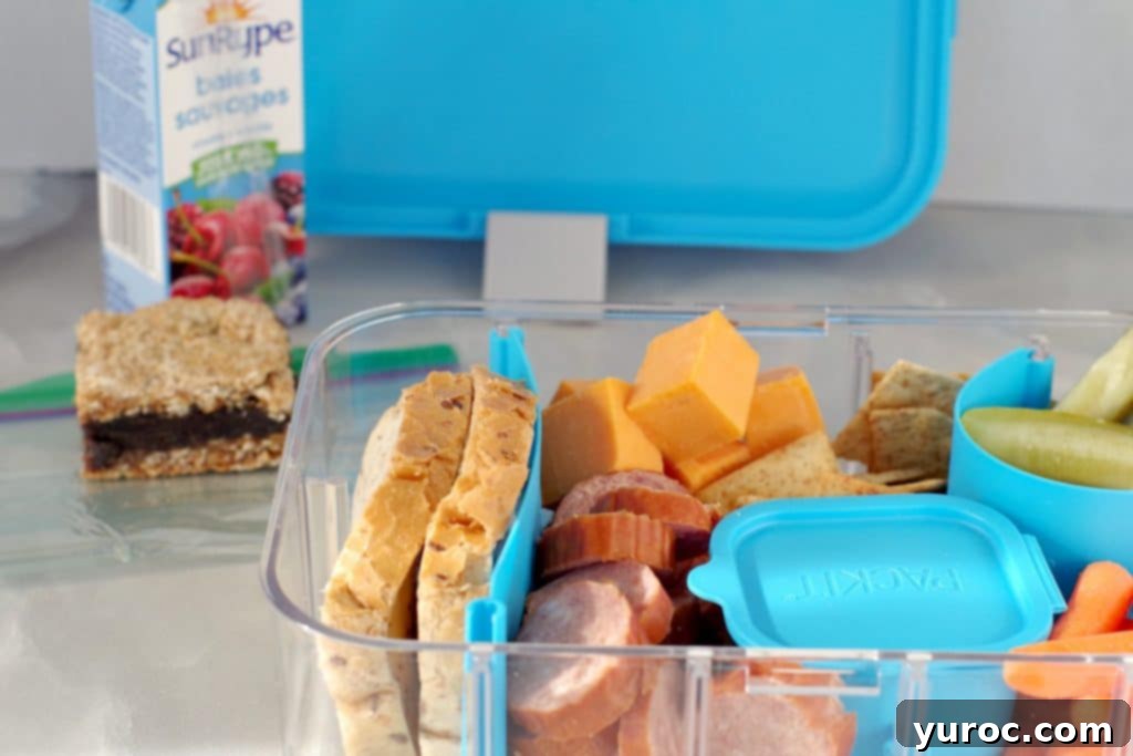 Filled Ukrainian Bento box with juice box, date square and bento box lid in background