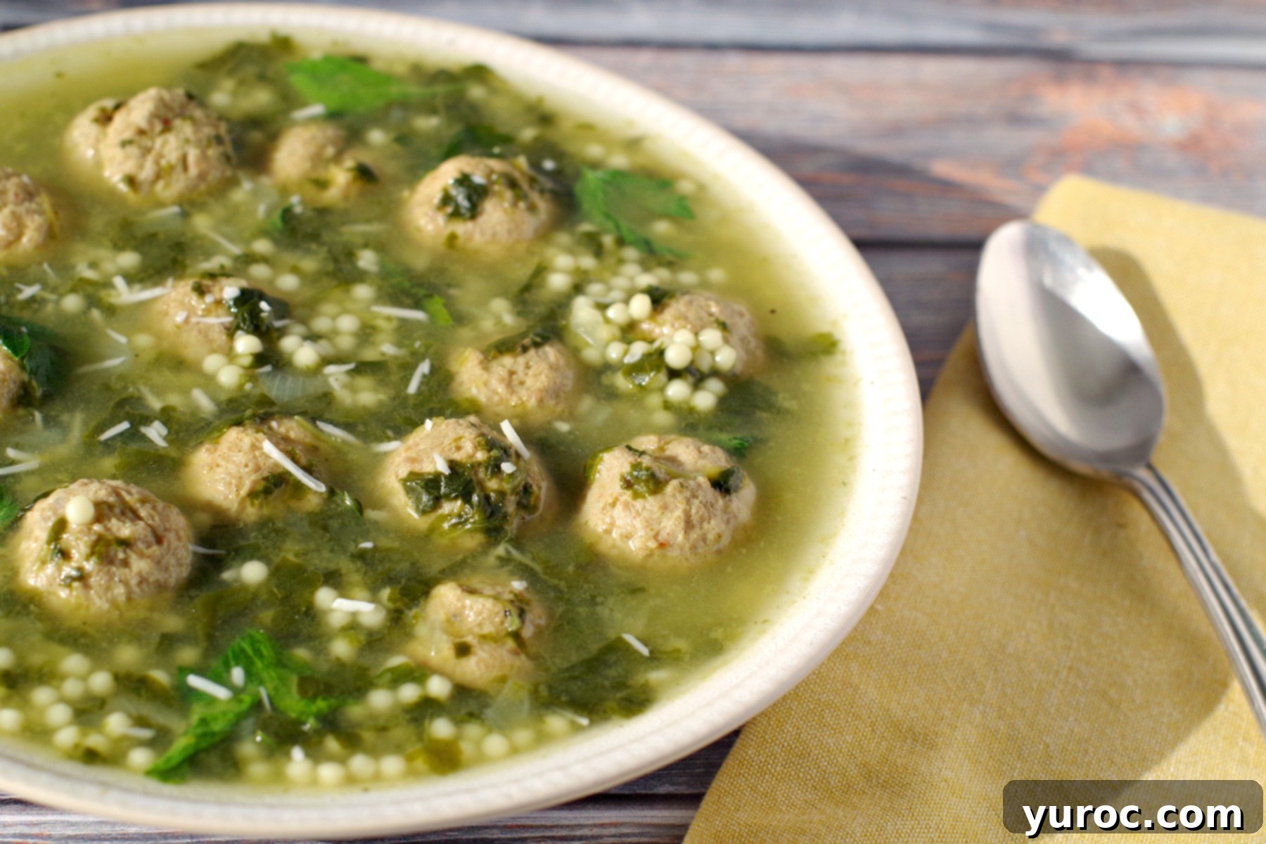 Easy Italian Wedding soup in beige bowl with yellow napkin